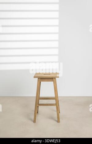 Elegante sedia in legno dal design minimalista, perfetta per interni moderni. La finitura in legno naturale aggiunge calore ed eleganza, rendendolo ideale per la cura Foto Stock