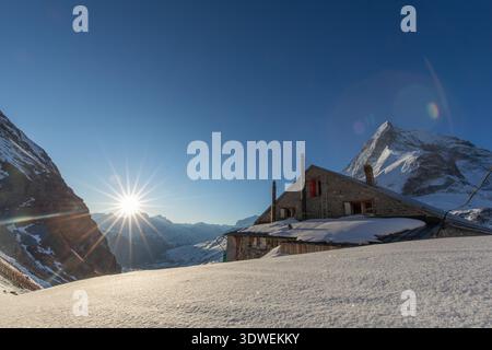 Una splendida alba illumina la capanna di Schonbiel innevata, situata vicino a Zermatt nel Vallese, in Svizzera, con l'imponente Cervino sul retro Foto Stock