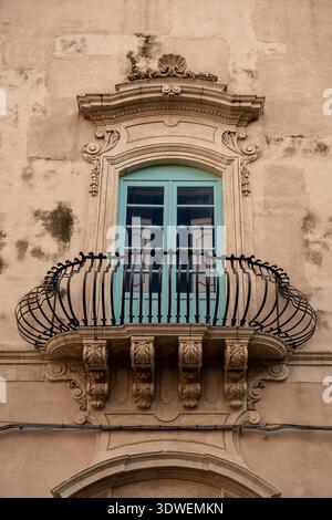Finestra turchese con balcone in ferro battuto su facciata in pietra barocca Foto Stock