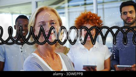 Donna matura sorridente che indossa cardigan grigio e pendente in un ufficio moderno, con forma d'onda Foto Stock