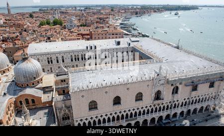 Veduta aerea dello storico Palazzo Ducale di Venezia, con lo scintillante Mare Adriatico su un lato e l'iconica Basilica di San Marco sulla o Foto Stock