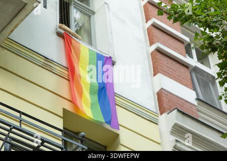 Berlino, Germania - 19 agosto 2025: La bandiera dell'Arcobaleno è esposta dalla finestra dell'edificio urbano della città. Foto Stock