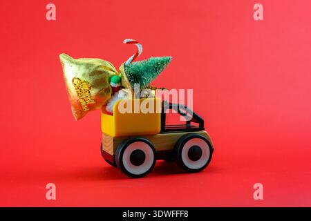 Un camion giocattolo porta con sé una borsa di regali per Natale. Decorazione natalizia. Foto Stock