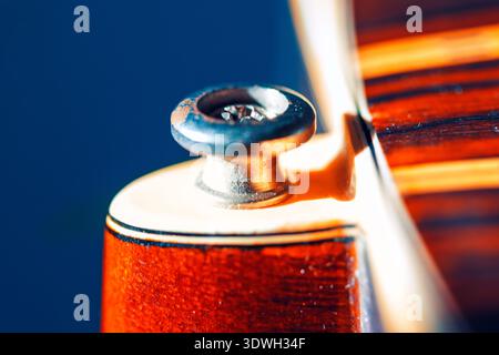 Il bottone per la tracolla per chitarra mette in risalto la grana fine del legno e la finitura lucida del corpo dello strumento. Le calde tonalità arancio e marrone contrastano splendidamente con l Foto Stock