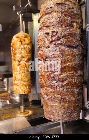 Primo piano di Spinning Shawarma e Doner Kebab Meat su Vertical Rotisserie Foto Stock