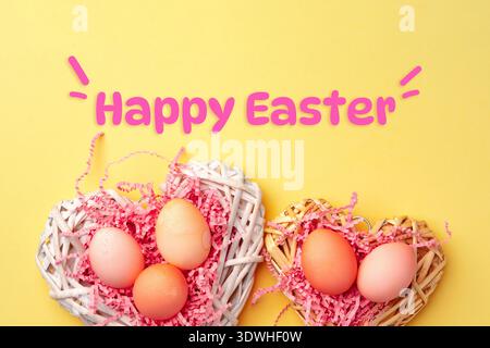 Felice festa di Pasqua con uova colorate nei nidi su sfondo giallo Foto Stock
