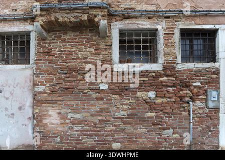 Facciata in mattoni antichi con finestre a reticolo, Venezia, Veneto, Italia Foto Stock