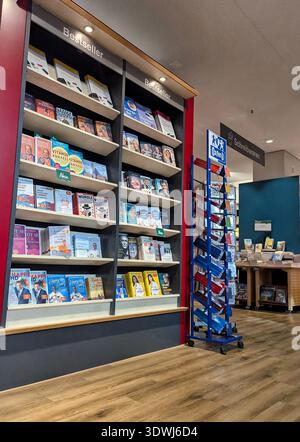 Pforzheim Germania 25 febbraio 2026 Libreria in primo piano con riviste, copertine colorate e spine organizzate etichette pulite, scaffalature in legno e Soft Foto Stock