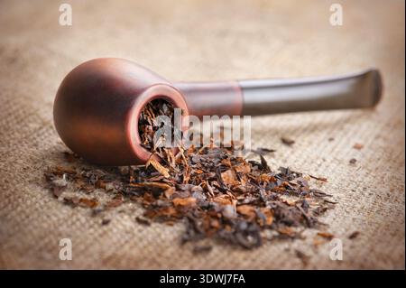 Tubo di fumo e tabacco sulla tela di lino sfondo Foto Stock
