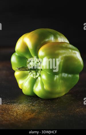 Peperone verde dolce su fondo scuro. Peperone verde giallo fresco (capsicum) Foto Stock