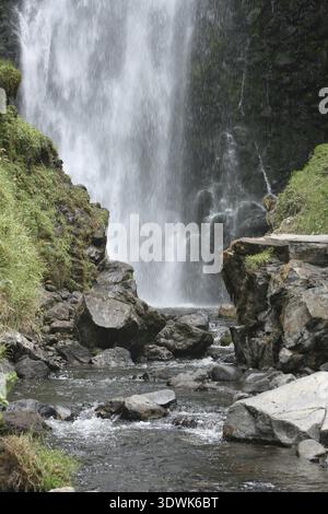 Le cascate Peguche si estendono su una scogliera in una piscina e continuano a valle in un piccolo fiume vicino a Otavalo, Ecuador Foto Stock