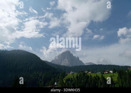 Ampia vista panoramica del villaggio di Ortisei, incastonato sotto il maestoso massiccio del Sassolungo. Foto Stock