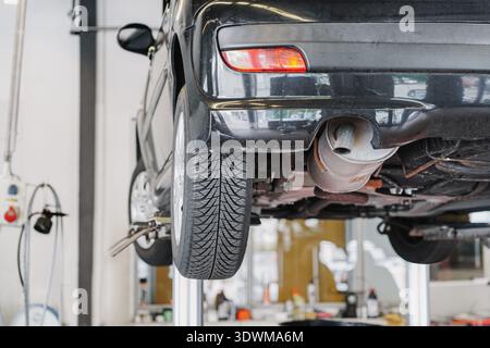 auto su un ascensore nella stazione di servizio di riparazione auto Foto Stock