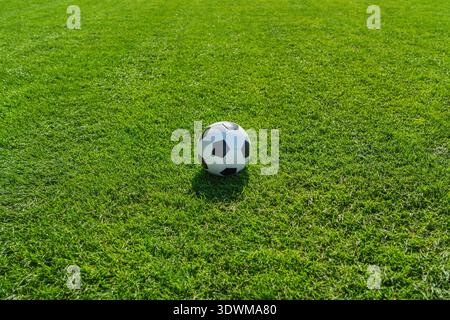 erba verde texture con una palla da calcio - erba sintetica ben curata in giardino Foto Stock