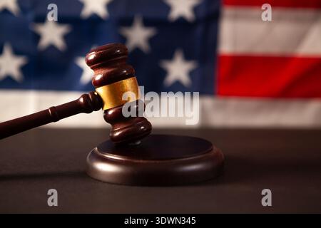 Tema della legge, mazzuolo di giudice, martelletto di legno sullo sfondo della bandiera degli Stati Uniti Foto Stock