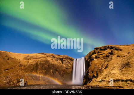 Islanda, Sudurland, Skogar, aurora boreale di fronte a Skogafoss Foto Stock