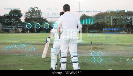 In piedi due giocatori di cricket bianchi che si preparano a battere sul campo con la mazza, i ceppi arancioni e le sovrapposizioni Foto Stock