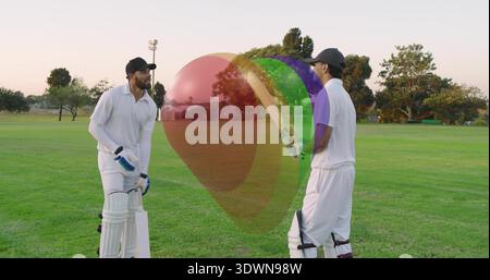 Due giocatori di cricket in divisa bianca che praticano e parlano su un terreno erboso al crepuscolo, pipistrello e ceppi Foto Stock