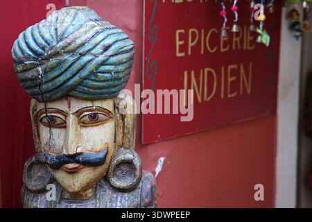Tradizionale figura in legno intagliato con turbante blu e baffi fa da guardia all'ingresso di un'épicerie indiana a Vieux Nice Foto Stock