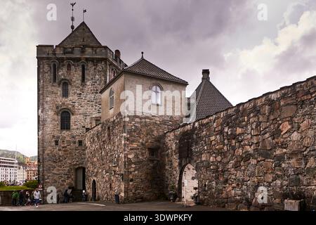 Vista delle antiche mura di pietra e di un'importante torre della fortezza di Bergenhus, un importante sito storico a Bergen, Norvegia. Caratteristiche dell'architettura Foto Stock