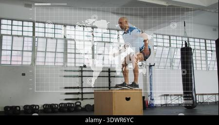 Uomo che atterra in camicia blu, pantaloncini che eseguono box jump in palestra, con HUD e plyo box Foto Stock