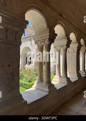 Giardino del chiostro dell'Abbaye de Sénanque in Provenza, Francia, con archi romanici e giardino del monastero medievale ben curato. Foto Stock