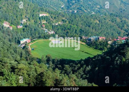 Il campo da golf Naldehra è circondato da fitte foreste e da edifici residenziali sparsi a Shimla, con colline nebbiose in lontananza. Foto Stock