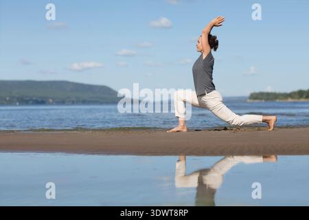 Donna che pratica tai chi chuan e yoga sulla spiaggia. Capacità di gestione cinese QIS energia. attività individuali all'aperto. Distanziamento sociale || modello rilasciato Foto Stock