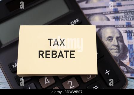 Testo del rimborso fiscale su una nota cartacea e una calcolatrice Foto Stock