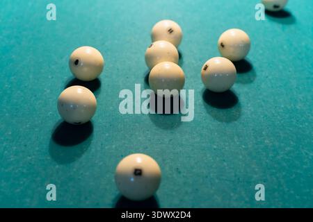 Palline bianche sparse su un tavolo da biliardo verde alla fine di una partita Foto Stock