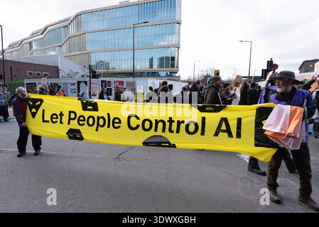 Londra, Regno Unito. 28 febbraio 2026. Si vede un banner che dice "Let the People Control ai", con il nuovo quartier generale di Londra incompiuto di Google sullo sfondo, come attivisti di "Pause ai" e "Pull the Plug" che marciano dagli uffici di OpenAI a Google e Meta che invitano i giganti della tecnologia a mettere in pausa lo sviluppo e l'implementazione dell'intelligenza artificiale (ai). Citando preoccupazioni quali la riservatezza dei dati, la distruzione del lavoro, le armi e gli impatti ambientali dei data center affamati di risorse, i manifestanti chiedevano un maggiore coinvolgimento pubblico e una maggiore consultazione sulla tecnologia. Crediti: Ron Fassbender/Alamy Live News Foto Stock