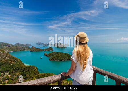 Giovane donna in piedi sul punto panoramico che si affaccia sulle isole del Parco Nazionale Marino di Ang Thong in Thailandia Foto Stock