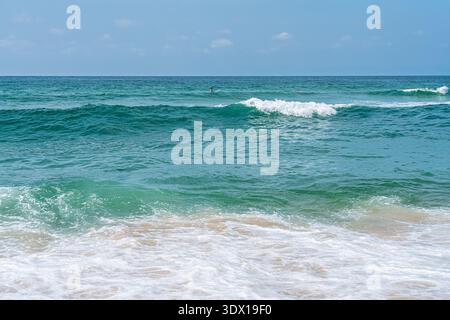 Onde turchesi dell'oceano che si infrangono sulla spiaggia di Sandy E offrono Una tranquilla vista del paesaggio costiero Foto Stock
