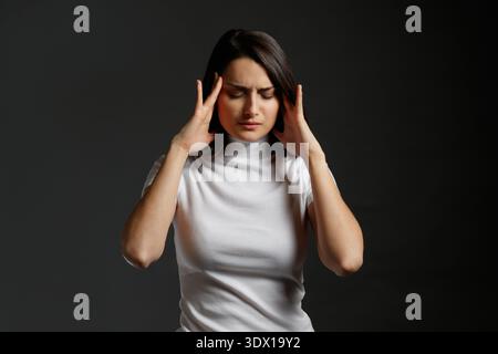 Giovane donna che soffre di grave mal di testa o emicrania Foto Stock