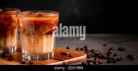 Caffè ghiacciato in un bicchiere con panna versata. Bevanda estiva fredda. Foto Stock