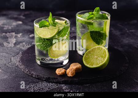 Cocktail analcolico estivo rinfrescante mojito con ghiaccio, menta fresca e lime, focus selettivo Foto Stock