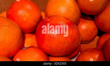 Arance rosse dolci in grandi casse sugli scaffali dei negozi. Esposizione e vendita di frutta. Foto Stock