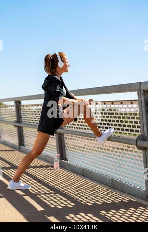 Concetto di jogging in città: Donna che si riscalda prima di allenarsi. Foto Stock