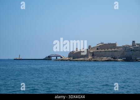 Ammira il Grand Harbour fino al ponte ad arco St. Elmo Breakwater Bridge e ai bastioni di Fort St. Elmo, con il blu profondo del Mediterraneo sotto il cielo limpido dell'estate Foto Stock