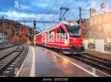 Moderno treno rosso sulla stazione ferroviaria di montagna nelle Alpi svizzere Foto Stock