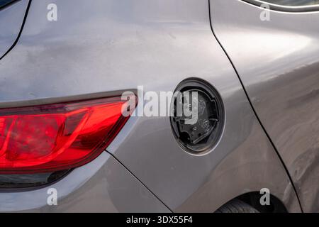 Vista posteriore di un'auto grigia che mostra un coperchio dello sportello del serbatoio del carburante mancante o rotto Foto Stock