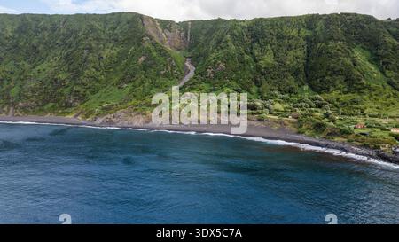 Faial, Isole Azzorre, Portogallo splendida vista sull'oceano con una scogliera sullo sfondo. L'acqua è calma e il cielo è limpido Foto Stock