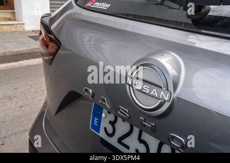 Barcellona, Spagna - 7 febbraio 2026: Primo piano del logo Nissan cromato e della scritta Qashqai su un SUV grigio, che illustra l'industria automobilistica Foto Stock