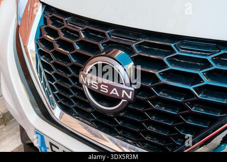 Barcellona, Spagna - 21 febbraio 2026: Dettaglio ravvicinato della griglia frontale e emblema metallico di un veicolo Nissan bianco, ideale per l'industria automobilistica Foto Stock