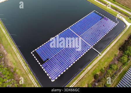 Vista dall'alto dell'impianto fotovoltaico galleggiante con molte file di pannelli solari per la produzione di energia elettrica pulita. Concetto di rinnovabile Foto Stock