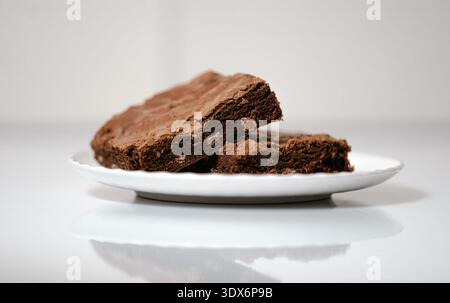 Primo piano di due brownie al cioccolato servite su un piatto di porcellana bianca. Foto Stock