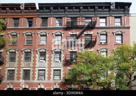 New York, vecchio edificio di appartamenti con decorazioni in pietra intorno alle cornici delle finestre Foto Stock