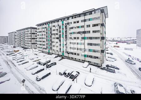 Edifici residenziali e parcheggio coperto da neve bianca durante le nevicate invernali nel distretto cittadino dell'europa orientale Foto Stock