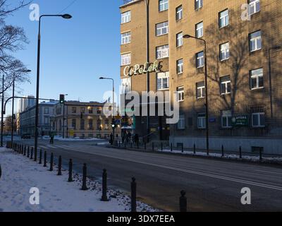 La gente cammina sulla strada vicino all'edificio con un cartello con il negozio in inverno Foto Stock