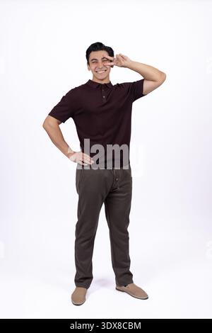 Giovane uomo che posa con la mano sull'anca con sicurezza Foto Stock